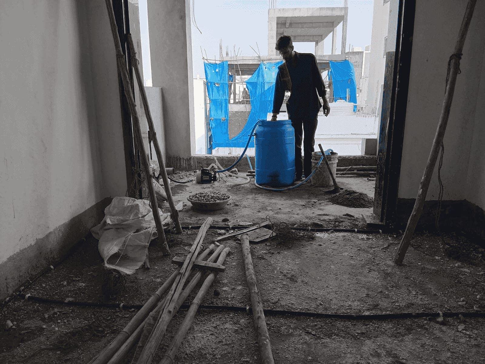SSD technician charging the anti-termite pipe network with termiticide from a blue drum