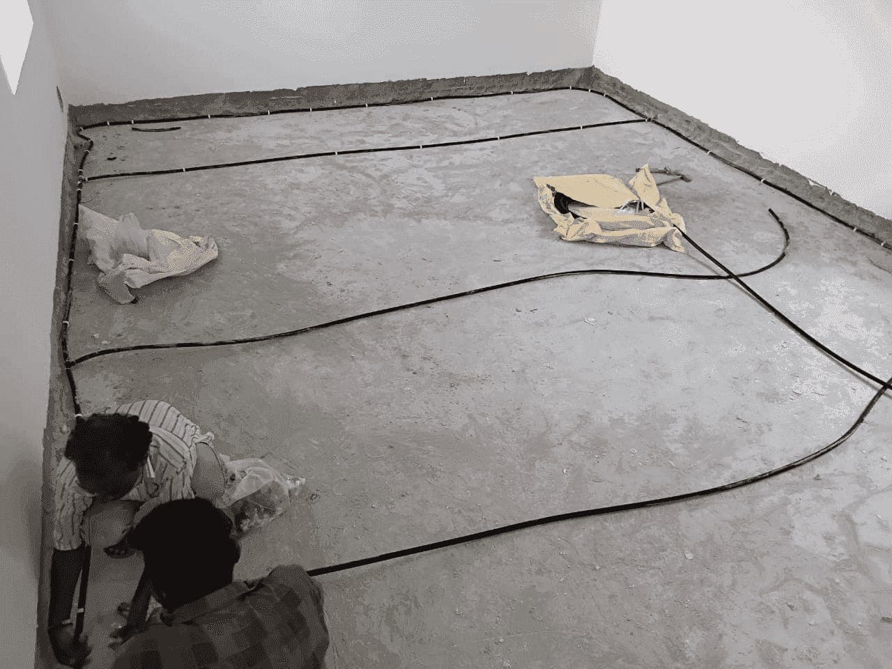 SSD technicians laying and clipping anti-termite pipe on a concrete floor bed